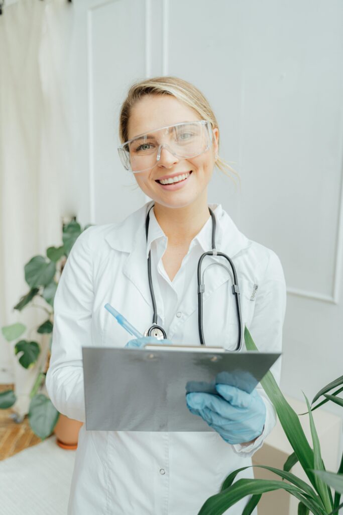 pexels-photo-5214995-5214995 Confident female doctor with clipboard in a bright medical office.