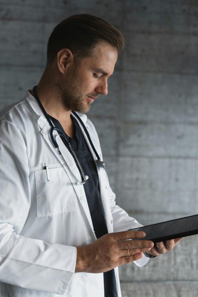 pexels-photo-5452293-5452293 Portrait of a confident male doctor using a tablet indoors.